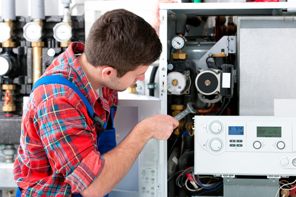 Heating technician repairing boiler controls in Los Altos