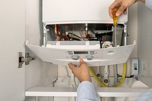 Heating technician repairing a residential boiler in Los Altos