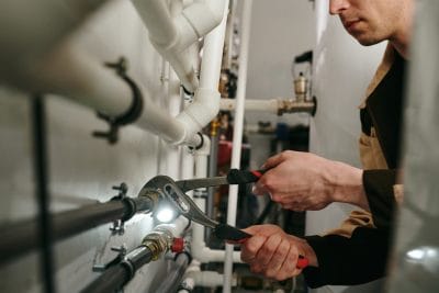 Technician inspecting commercial plumbing pipes in Los Altos