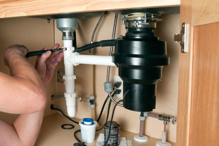 Plumber repairing a garbage disposal in Los Altos