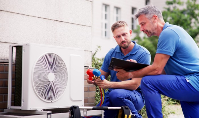 HVAC technicians installing an outdoor air conditioning unit in Los Altos