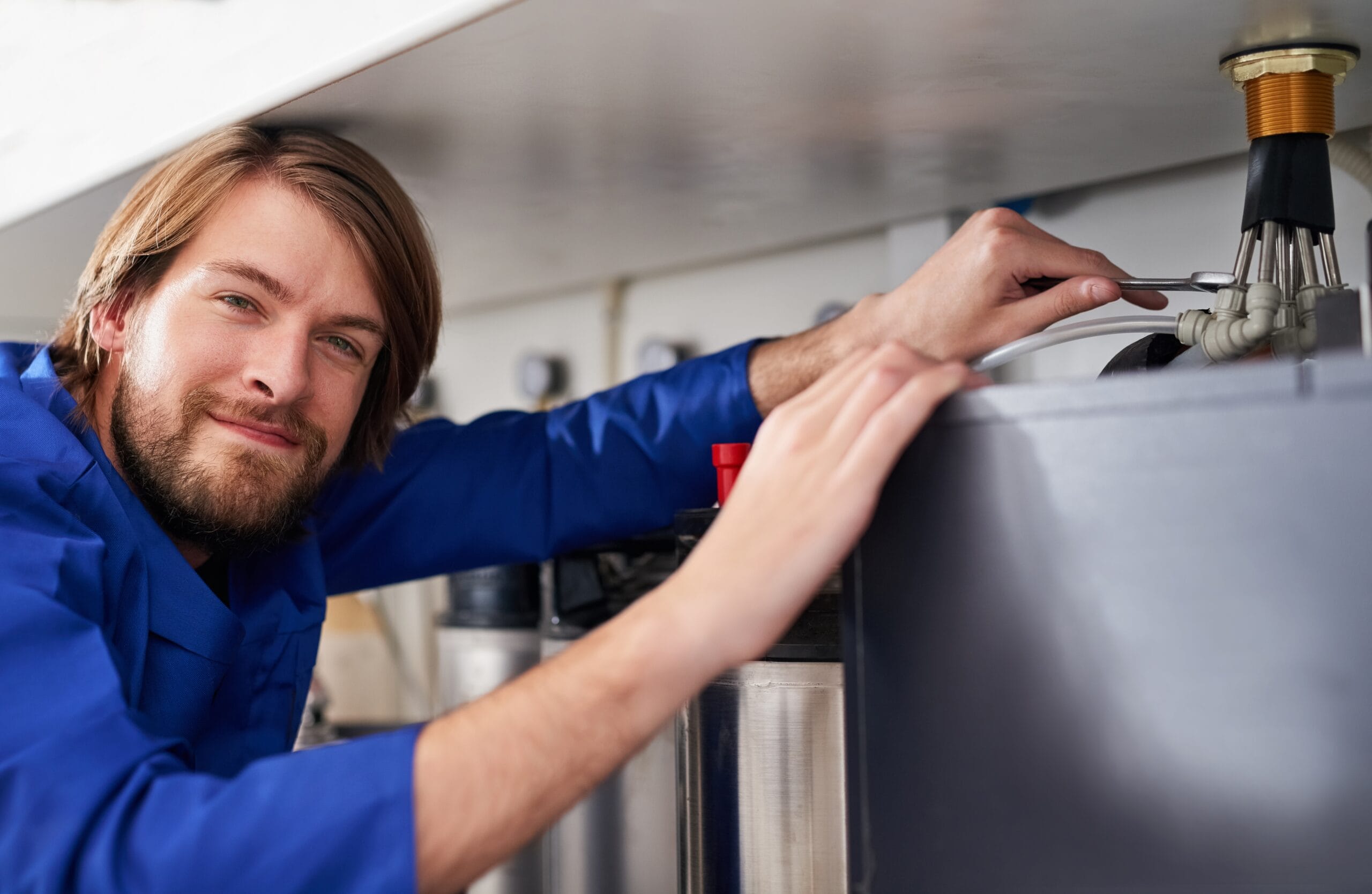 Technician servicing a residential water heater tank in Los Altos